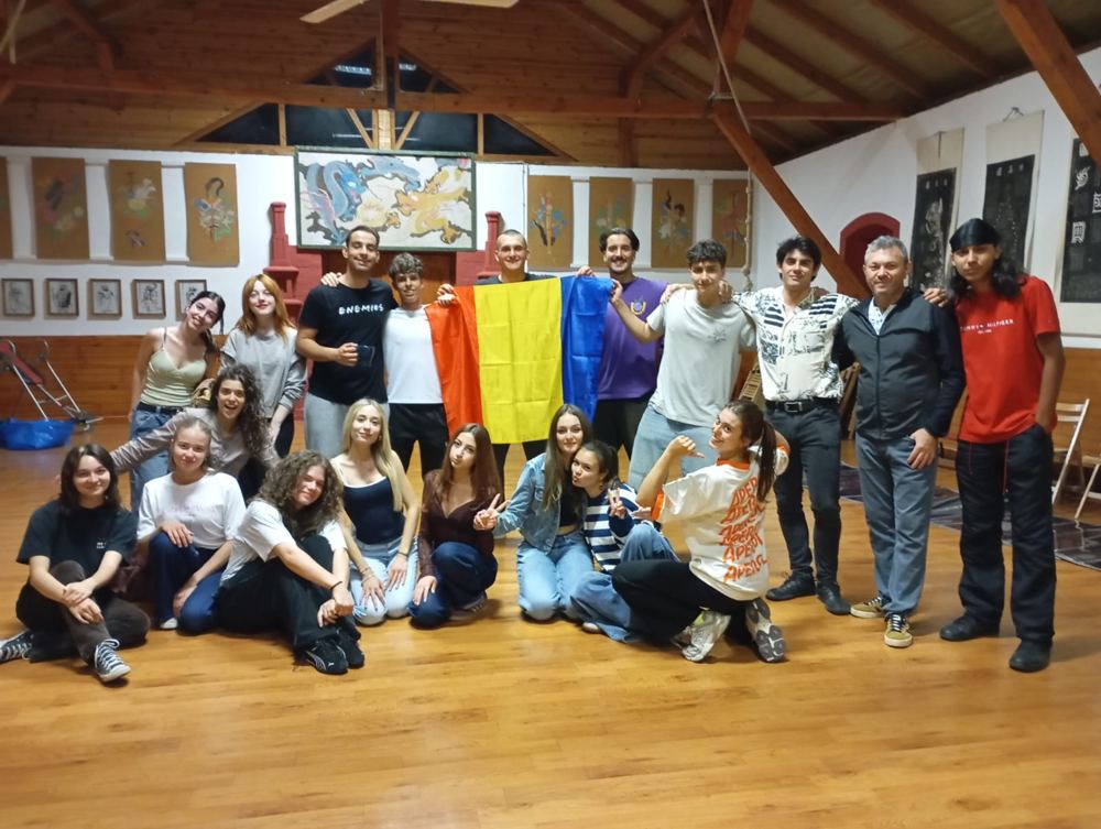 Internationale Gruppe mit Länderfahnen im Seminarraum